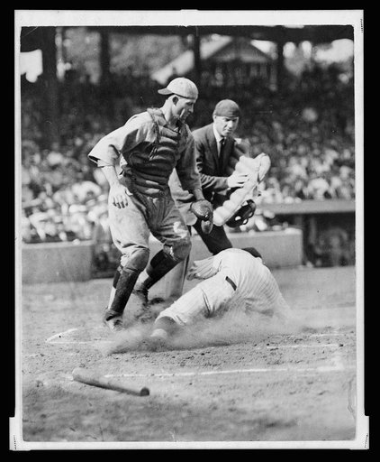 Umpire Dick Nallin is ready to make the call as Washington Senators' Earl McNeely safely slides into home plate at the feet of the Boston Red Sox catcher, George Bischoff, in the 1st inning. Senators beat the Red Sox 7-6
