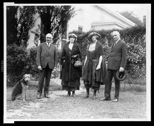Warren Harding with pet dog Laddie Boy in the yard at the White House, with "Pop" Anson and his daughters