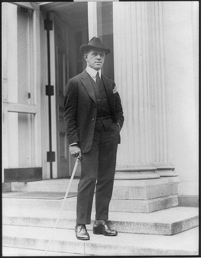 George Creel, 1876-1953, full length portrait, standing, facing left; on steps outside the White House