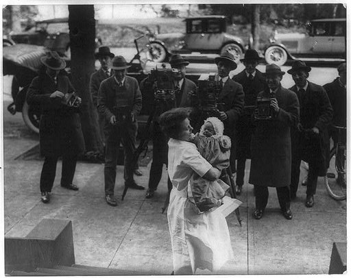Paulina Longworth, daughter of Alice Roosevelt Longworth, being held by nurse for first news photos by 8 news photographiers