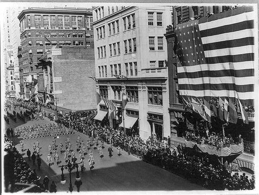 News photos of N.Y. National Guard units preparing for active duty on Mexican border, May-Nov. 1916: Departure of 7th Regiment, parading down 5th Avenue, passing gigantic U.S. flag