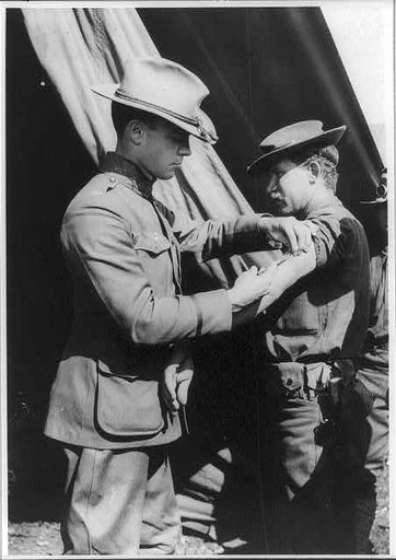 U.S. Army medical officer vaccinating soldier with arm injection, San Antonio, Texas
