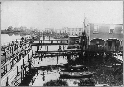 New York City - Jamaica Bay housing boom, 1915]: small boats moored beside houses built over water