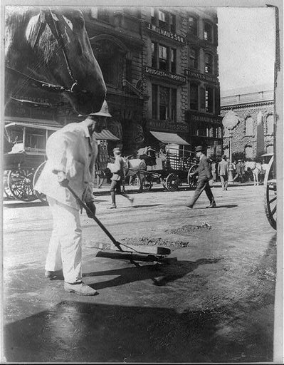 New York City sanitation dept. employee sweeping street, ca. 1910