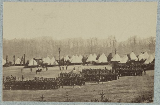 View of troops in formation with camp in background