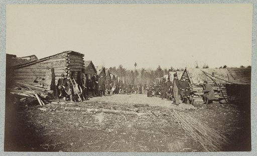 Union soldiers, in camp, posed in front of log buildings