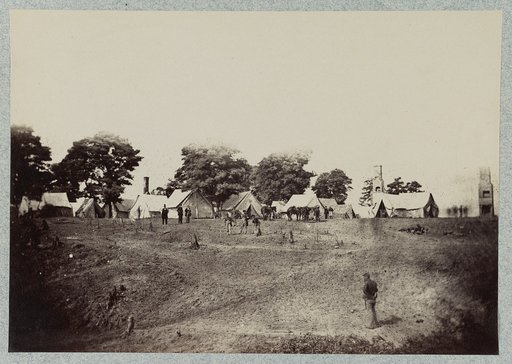 Union soldiers stand in front of their camp