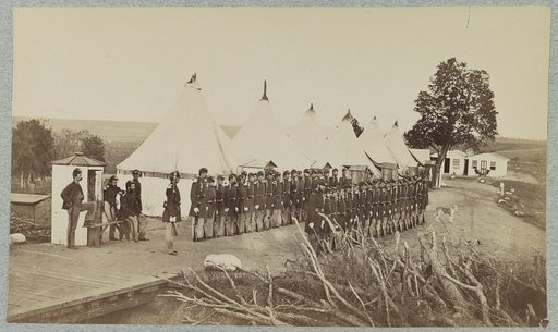 Union soldiers lined up in two rows in front of tents