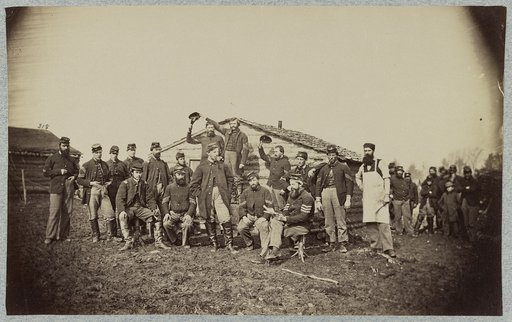 Group of soldiers gathered outside a cabin