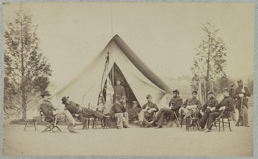 Group of soldiers relax in front of a tent