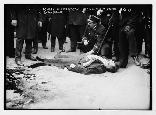 Policeman stooping over Ignatz Hildebrandt, killed in Union Square, anarchist riot, New York