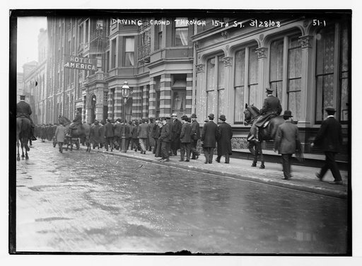 Driving crowd through 15th St., New York