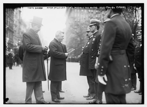 Commander [i.e. Commissioner] Bingham and Mayor McClellan pin medals on honor policeman in police parade, New York