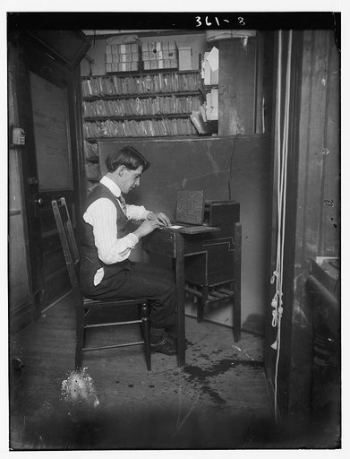 Man making a photographic contact print in an office, ca. 1909