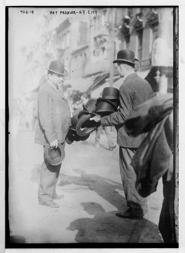 Hat Peddler and prospective buyer, on sidewalk, New York
