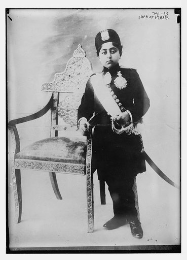 Shah of Persia, in uniform, standing by chair