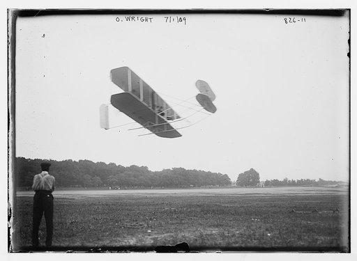 O. Wright and aeroplane, in flight over field
