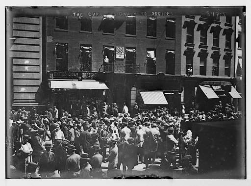 Crowd on curb in fron of building, signals to offices