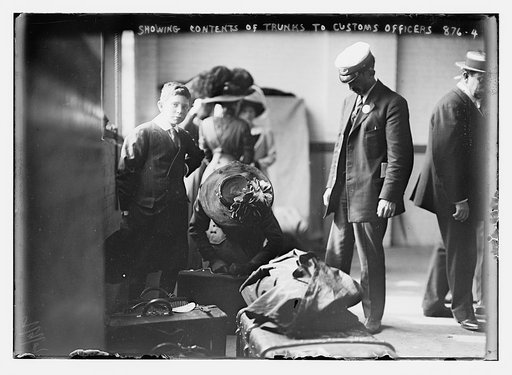 Woman showing baggage contents to customs officer, N.D.L. pier, New York