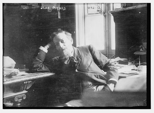 Jean Ricard leaning against desk