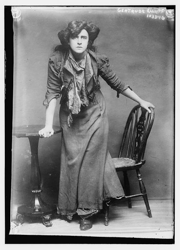 Gertrude Elliott posing between chair and table