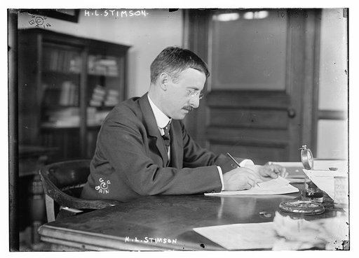H.L. Stimson at desk writing