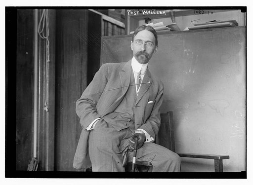 Post Wheeler with cane, casually leaning against chair