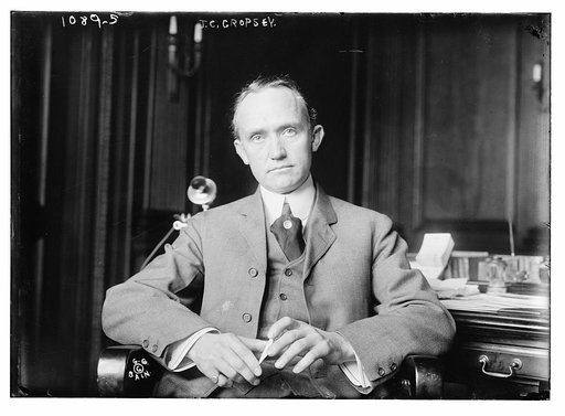 J.C. Cropsey seated at desk