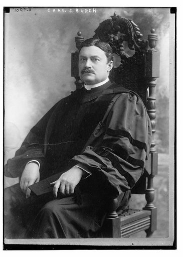 Chas. S. Burch seated in academic robe