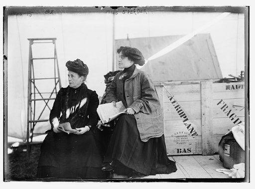 Miss Sperder, seated with another lady, holding newspaper