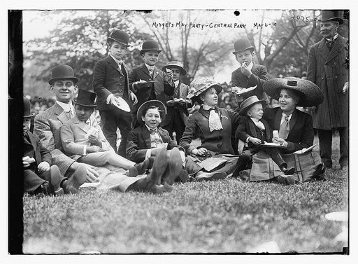 Midgets May Party - Central Park. Group seated on grass.