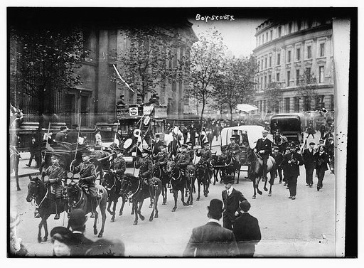 Boy Scouts.  Marching on horseback down a street.