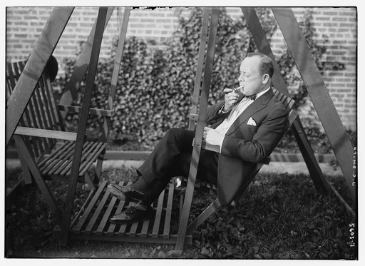 J.C. Smith [sitting outdoors, smoking