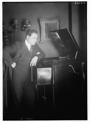 Beniamino Gigli standing next to phonograph