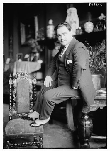 Beniamino Gigli seated on a table