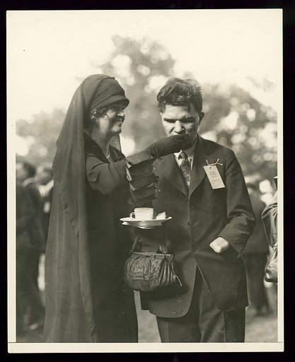 Rep. Edith Nourse Rogers of Mass. assists a disabled veteran in partaking of refreshments at the garden party at the White House given by President and Mrs. Coolidge