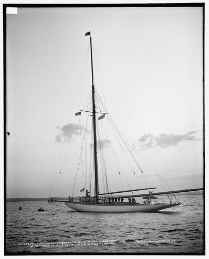 Victorious Columbia at mooring in the horseshoe after race of Oct. 4, 1901, flying winning pennants