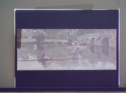 Sculling on river or lake by bridge