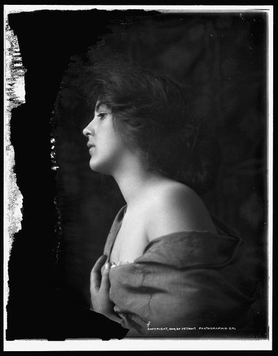 Woman model in profile with hand at bosom, half-length portrait