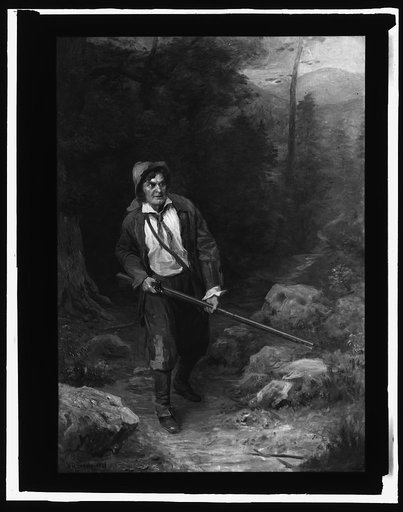 Man with rifle walking through woods