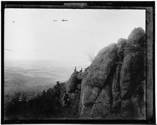 People on rocks overlooking valley