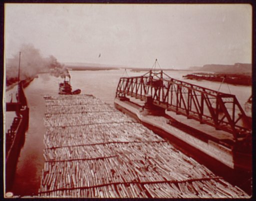 Winona, Minn., log raft passing drawbridge