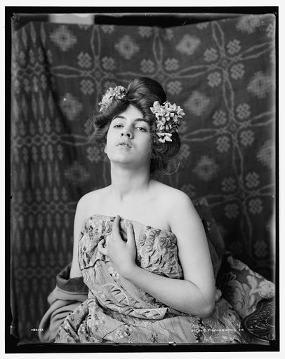 Model, flowers in hair, head tilted