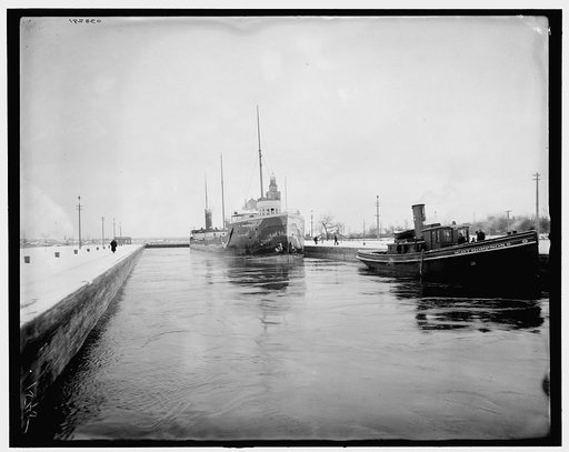 Cargo ship David M. Whitney and the tug CDT Thompson in canal, probably Sault Sainte Marie Canal