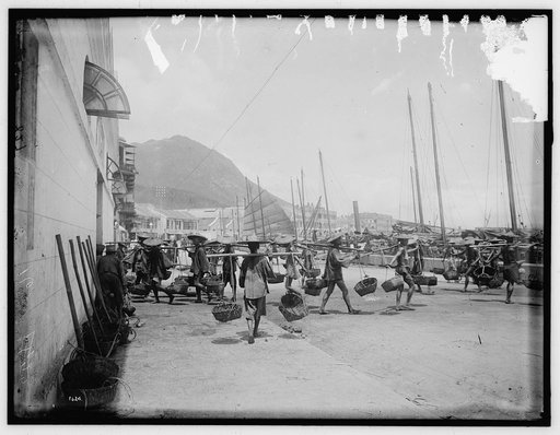 Coolies with basket yokes in Hong Kong harbor