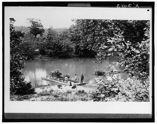Ferry boat loaded with mule cart at landing