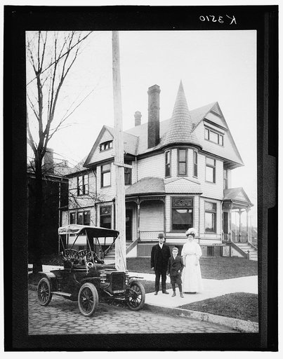 Man, woman, and boy, (possibly a family), standing in front of house with sign "Dr. Jas. N. Garber