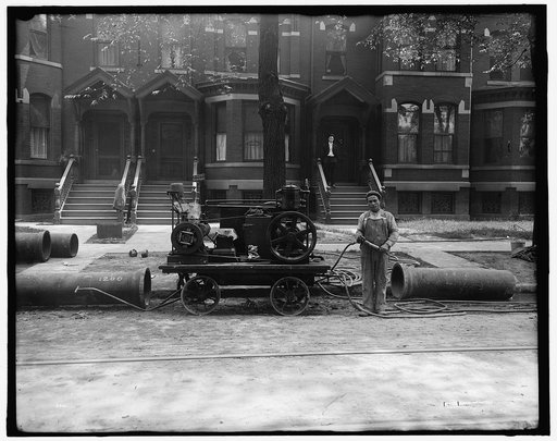 Worker, possibly doing pipeline construction for gas company, with cables and engine