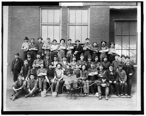 Group of workers posed with bucket cart outside Leland & Faulconer Manufacturing Co., Detroit, Michigan