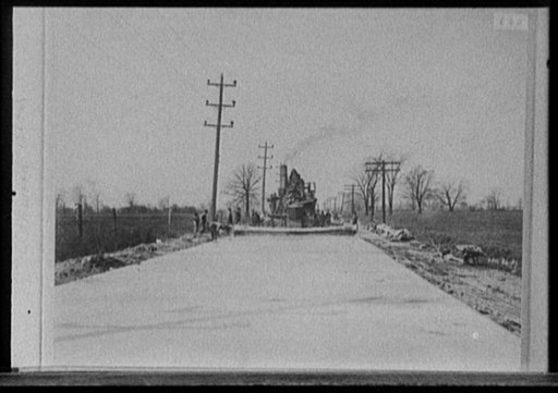 Steamroller grading road, probably Michigan